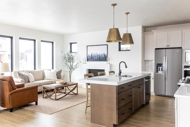6962 Elk Wallow Dr Unit 7, Park City, UT 84098 - kitchen featuring a sink, light wood-style floors, light countertops, appliances with stainless steel finishes, and open floor plan