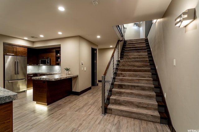 854 W Tawgoo Ct, Ivins, UT 84738 - kitchen featuring stainless steel appliances, a peninsula, visible vents, light wood-type flooring, and tasteful backsplash