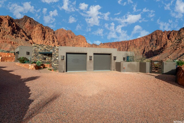854 W Tawgoo Ct, Ivins, UT 84738 - adobe home with a gate, a mountain view, dirt driveway, and stucco siding