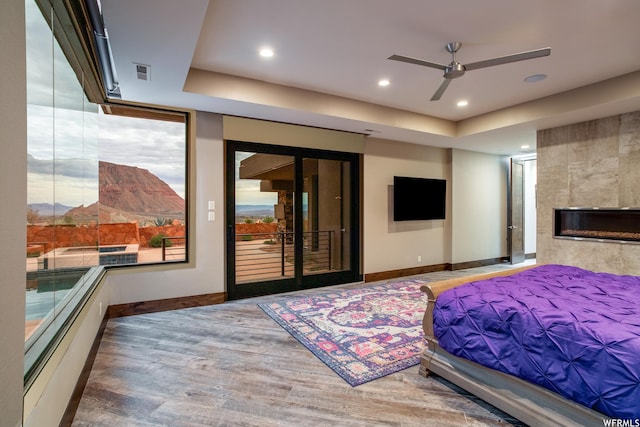 854 W Tawgoo Ct, Ivins, UT 84738 - bedroom featuring baseboards, visible vents, a tile fireplace, wood finished floors, and access to outside