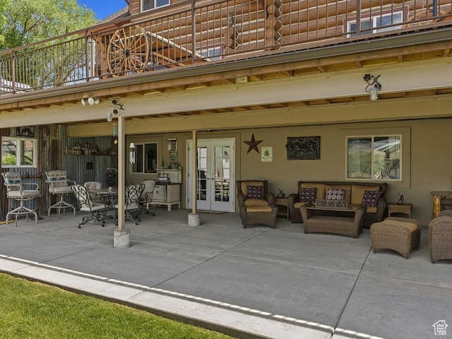 view of patio featuring a balcony, french doors, and an outdoor living space