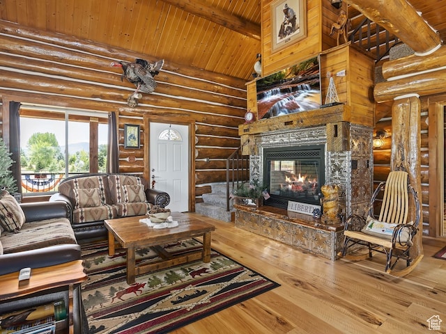 living room featuring beamed ceiling, rustic walls, light hardwood / wood-style floors, high vaulted ceiling, and wooden ceiling