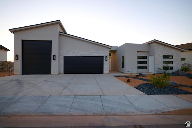 contemporary home featuring driveway, stucco siding, and an attached garage