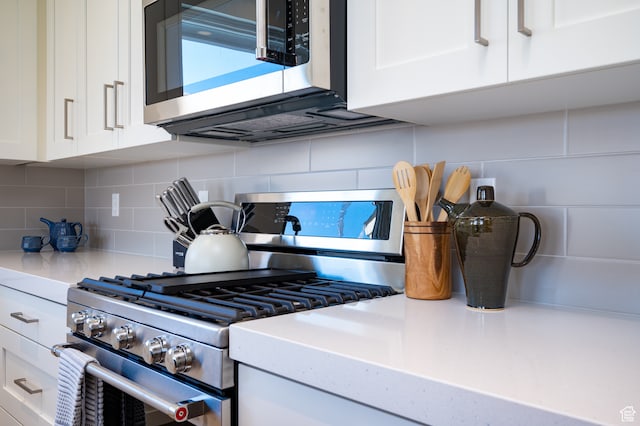 kitchen with white cabinetry, light countertops, tasteful backsplash, and appliances with stainless steel finishes