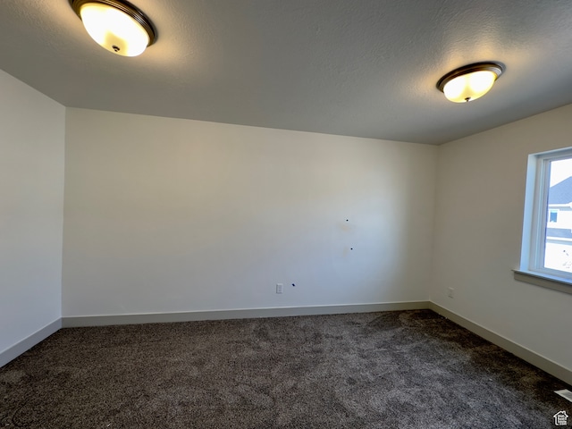 216 W Seasons Ln Unit 46, Garden City, UT 84028 - spare room with dark colored carpet, baseboards, and a textured ceiling