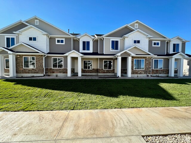 216 W Seasons Ln Unit 46, Garden City, UT 84028 - view of front of house featuring stone siding, a front yard, and board and batten siding