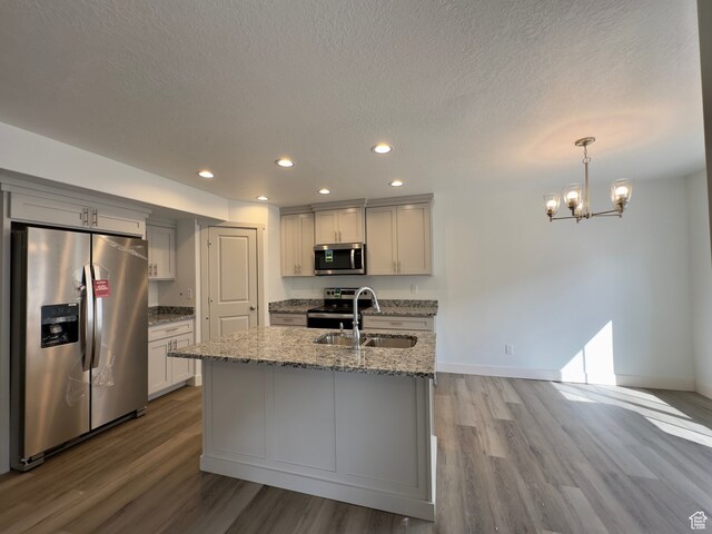 216 W Seasons Ln Unit 46, Garden City, UT 84028 - kitchen with appliances with stainless steel finishes, a sink, wood finished floors, recessed lighting, and light stone counters