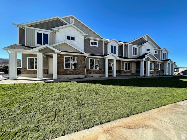 216 W Seasons Ln Unit 46, Garden City, UT 84028 - view of front facade featuring a porch, stone siding, board and batten siding, and a front lawn