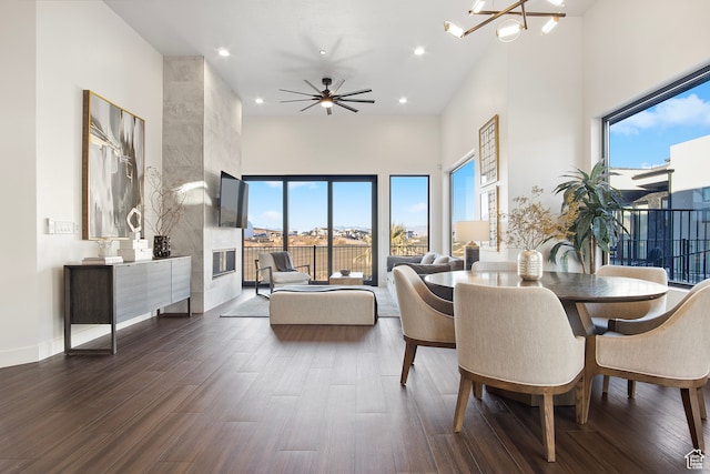 1560 W Torrey Pines Rd, Hurricane, UT 84737 - dining area featuring plenty of natural light, a tile fireplace, ceiling fan with notable chandelier, and dark hardwood / wood-style flooring