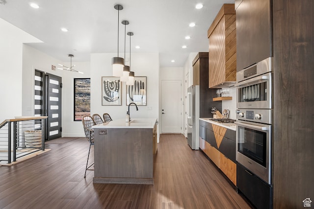 1560 W Torrey Pines Rd, Hurricane, UT 84737 - kitchen featuring a breakfast bar, hanging light fixtures, stainless steel appliances, and dark wood-type flooring