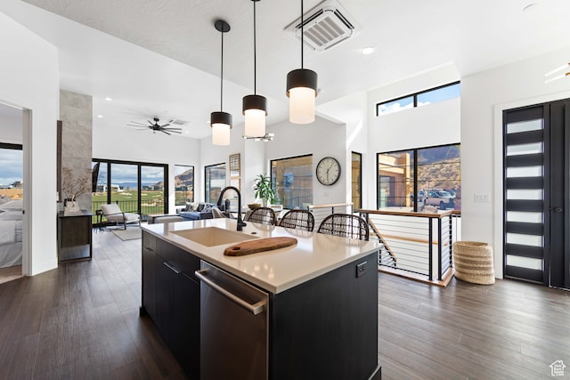 1560 W Torrey Pines Rd, Hurricane, UT 84737 - kitchen with stainless steel dishwasher, hanging light fixtures, sink, a healthy amount of sunlight, and a kitchen island with sink