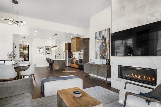 1560 W Torrey Pines Rd, Hurricane, UT 84737 - living room featuring dark hardwood / wood-style floors, a fireplace, sink, and a notable chandelier
