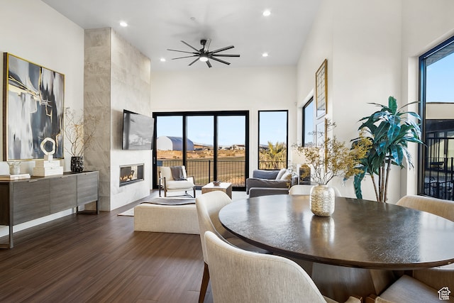 1560 W Torrey Pines Rd, Hurricane, UT 84737 - dining area with a high ceiling, ceiling fan, dark wood-type flooring, and a tiled fireplace