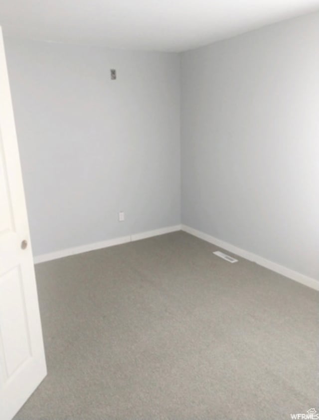 spare room featuring dark carpet