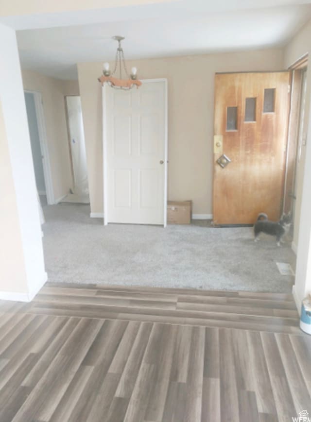 carpeted empty room with an inviting chandelier