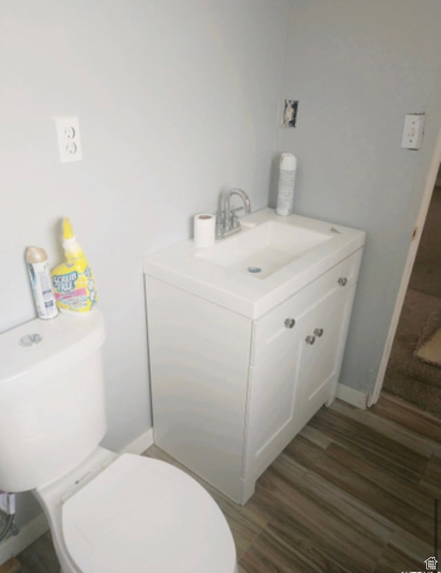 bathroom featuring toilet, vanity, and wood-type flooring