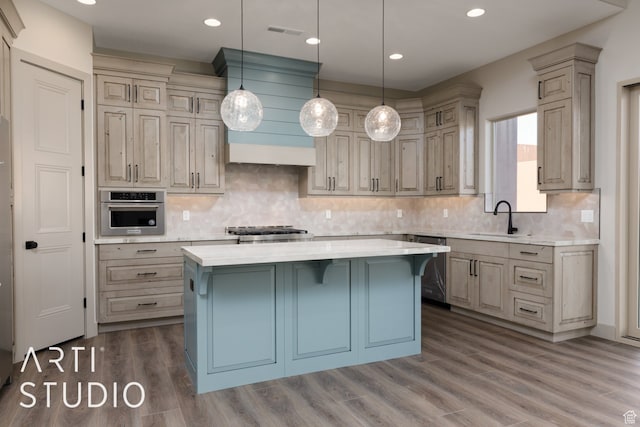 3209 S Dyami Vw Unit 11, Hurricane, UT 84737 - kitchen featuring dark wood-type flooring, appliances with stainless steel finishes, a breakfast bar area, a kitchen island, and hanging light fixtures