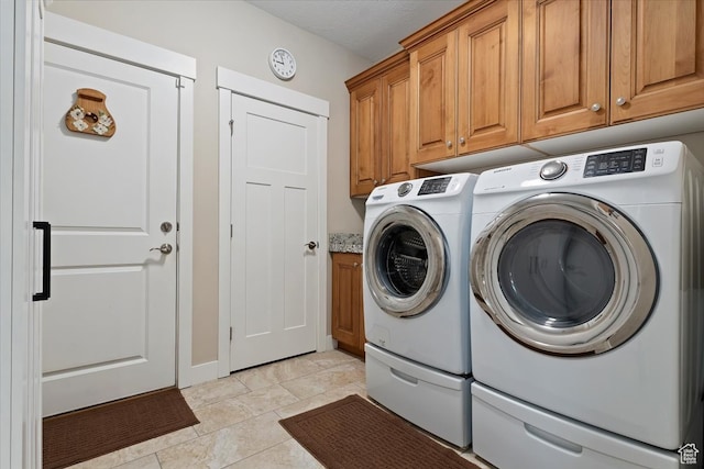 laundry room featuring cabinets, light tile floors, and washer and dryer