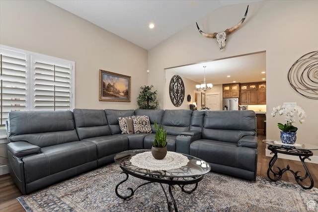 living room featuring a chandelier, high vaulted ceiling, and dark wood-type flooring