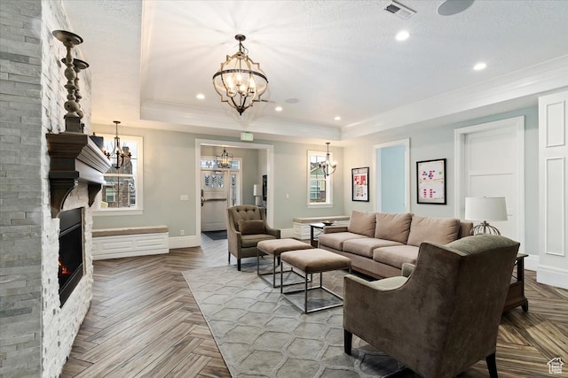 living room featuring light parquet flooring, a notable chandelier, brick wall, and a tray ceiling
