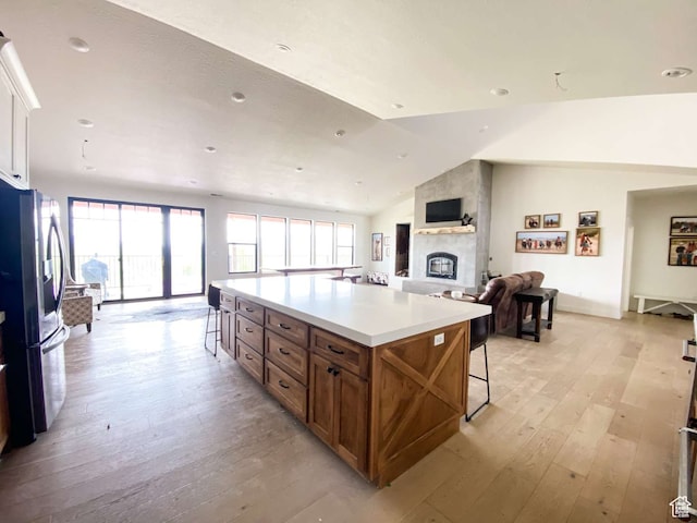 3213 N 4900 W, Malad City, ID 83252 - kitchen with a large fireplace, a breakfast bar area, light hardwood / wood-style floors, and lofted ceiling