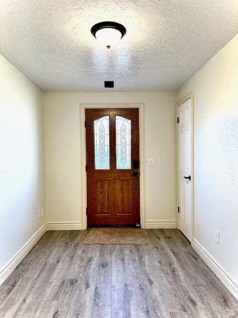 foyer featuring a textured ceiling and light wood-type flooring