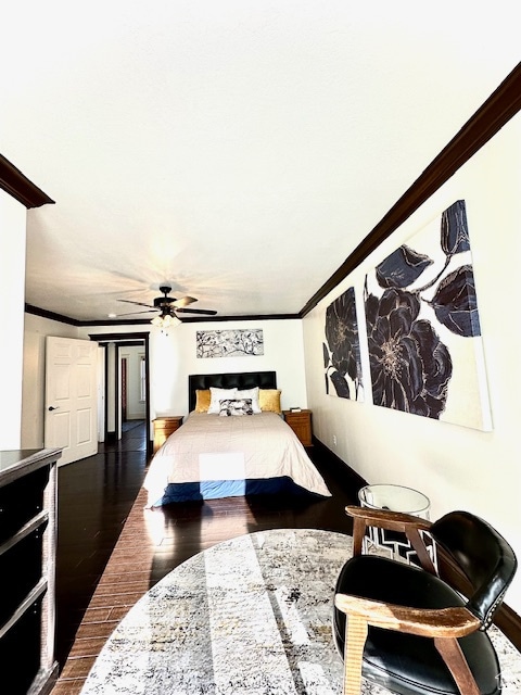 bedroom with ceiling fan, dark wood-type flooring, and crown molding