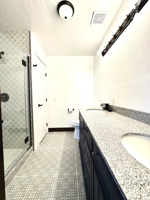 bathroom featuring vanity, toilet, and an enclosed shower