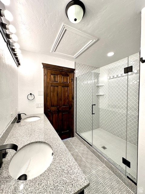 bathroom with a textured ceiling, an enclosed shower, and vanity
