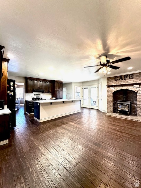kitchen featuring a kitchen island, plenty of natural light, a kitchen breakfast bar, dark hardwood / wood-style floors, and dark brown cabinets