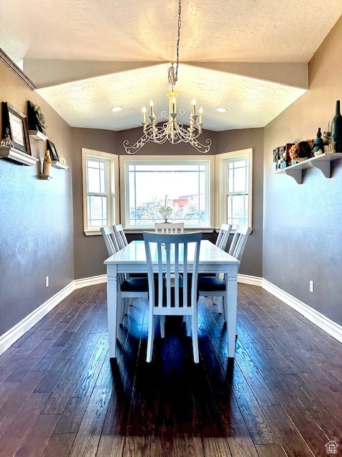 dining area featuring a textured ceiling, dark hardwood / wood-style flooring, and a chandelier