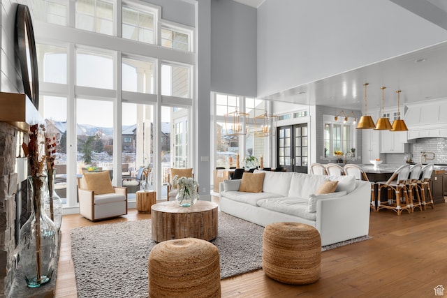 3297 W Blue Springs Ln, Bluffdale, UT 84065 - living room with a chandelier, a high ceiling, and light wood-type flooring