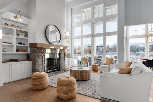 3297 W Blue Springs Ln, Bluffdale, UT 84065 - living room featuring a fireplace, a high ceiling, and light hardwood / wood-style flooring