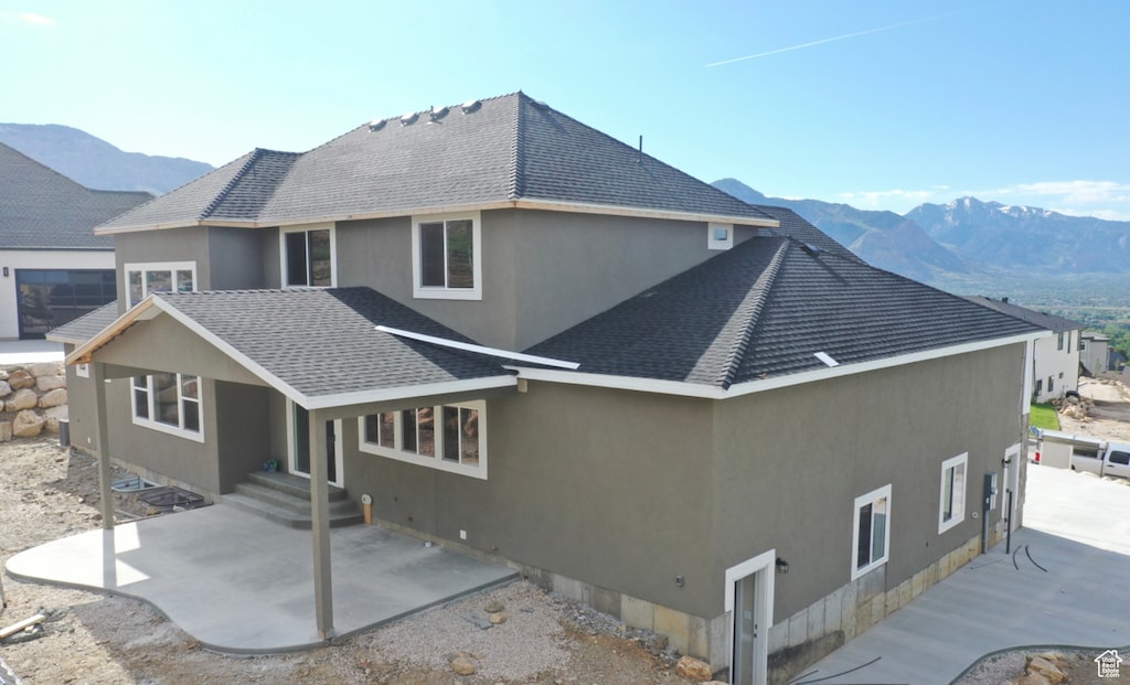 rear view of house featuring a patio area and a mountain view