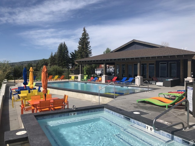 view of swimming pool featuring a patio, outdoor lounge area, and a hot tub