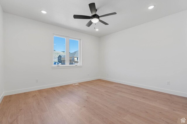 spare room featuring light wood-style floors and baseboards
