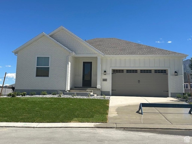 view of front of house with board and batten siding, concrete driveway, brick siding, and an attached garage