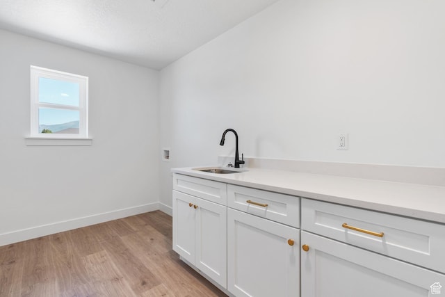 1263 Crest Dale Ln, Santaquin, UT 84655 - laundry area featuring hookup for a washing machine, baseboards, a sink, light wood-style floors, and cabinet space