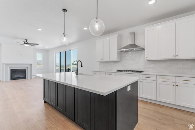 1263 Crest Dale Ln, Santaquin, UT 84655 - kitchen featuring light countertops, a ceiling fan, white cabinetry, gas stovetop, and wall chimney range hood