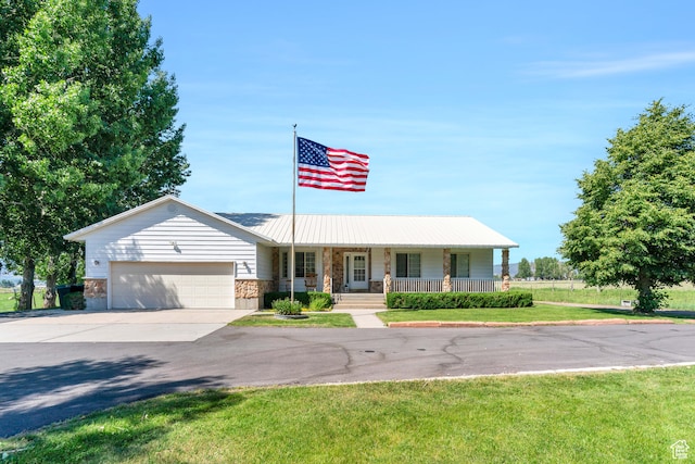 single story home with covered porch, a front lawn, and a garage