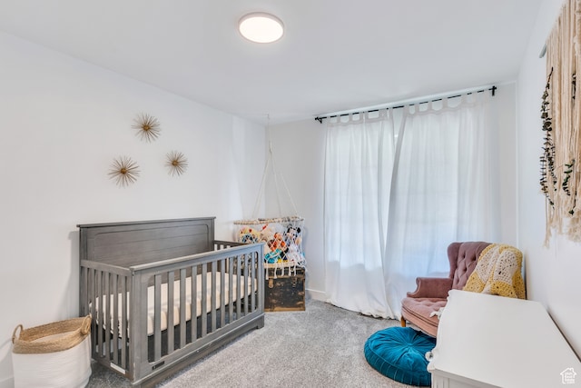 bedroom featuring a crib and light carpet