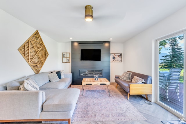 living room with a fireplace, light parquet flooring, and ceiling fan