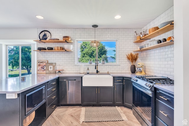 kitchen featuring appliances with stainless steel finishes, sink, light parquet flooring, tasteful backsplash, and pendant lighting