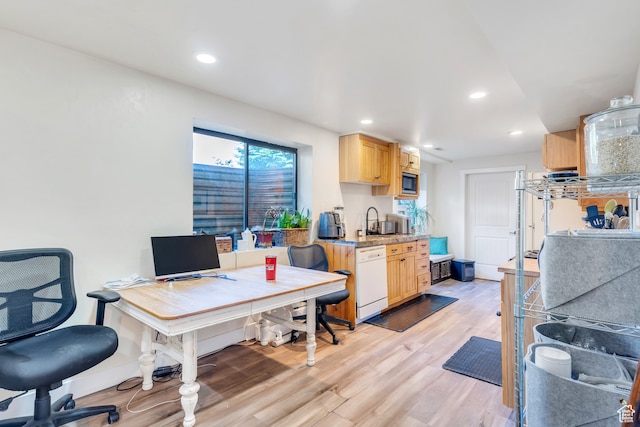 office with light hardwood / wood-style floors and sink