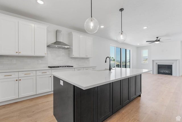 1208 W View Dr S, Santaquin, UT 84655 - kitchen featuring wall chimney range hood, gas cooktop, white cabinetry, light countertops, and tasteful backsplash