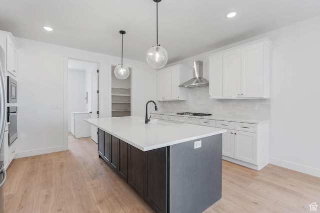 1208 W View Dr S, Santaquin, UT 84655 - kitchen featuring wall chimney exhaust hood, light countertops, white cabinetry, light wood-type flooring, and recessed lighting