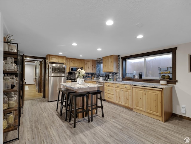 1271 E Oakridge Rd S, Park City, UT 84098 - kitchen featuring stainless steel appliances, a breakfast bar, light wood-type flooring, and a center island
