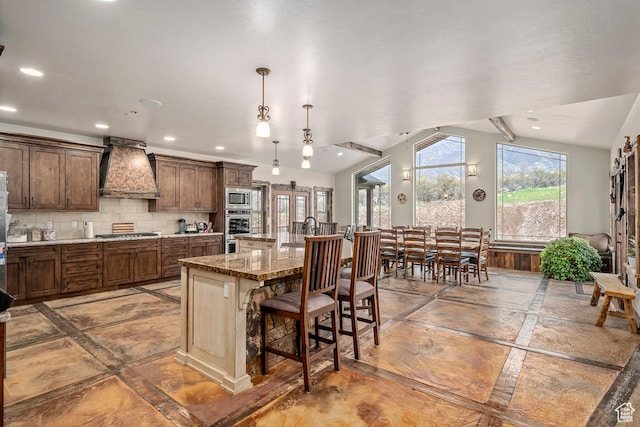 14975 S Canyon Rd, Santaquin, UT 84655 - kitchen featuring pendant lighting, a kitchen breakfast bar, appliances with stainless steel finishes, custom range hood, and backsplash