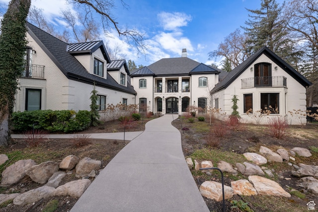 2227 E 5340 S, Holladay, UT 84117 - view of front of house with a balcony, a standing seam roof, a chimney, brick siding, and metal roof