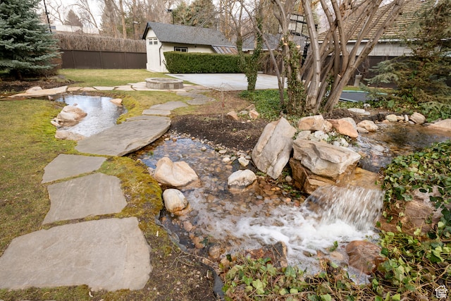2227 E 5340 S, Holladay, UT 84117 - view of yard featuring an outdoor fire pit, fence private yard, a garden pond, an outdoor structure, and a patio